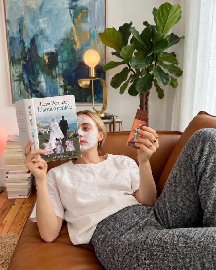 Ragazza sul divano con un libro e una tavoletta Choco Zero
